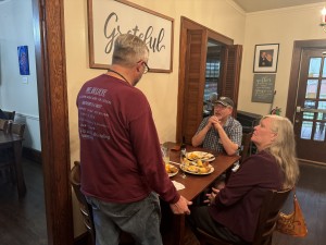 room with a table and people sitting and standing