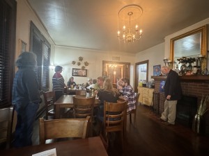 room with several tables and people sitting and standing