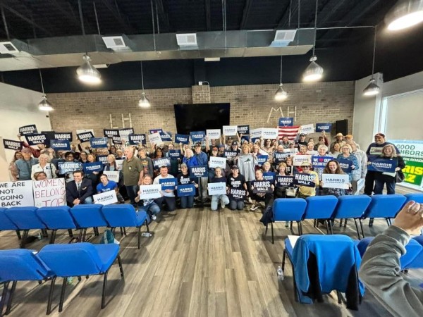 group photo with 100 people holding Harris signs